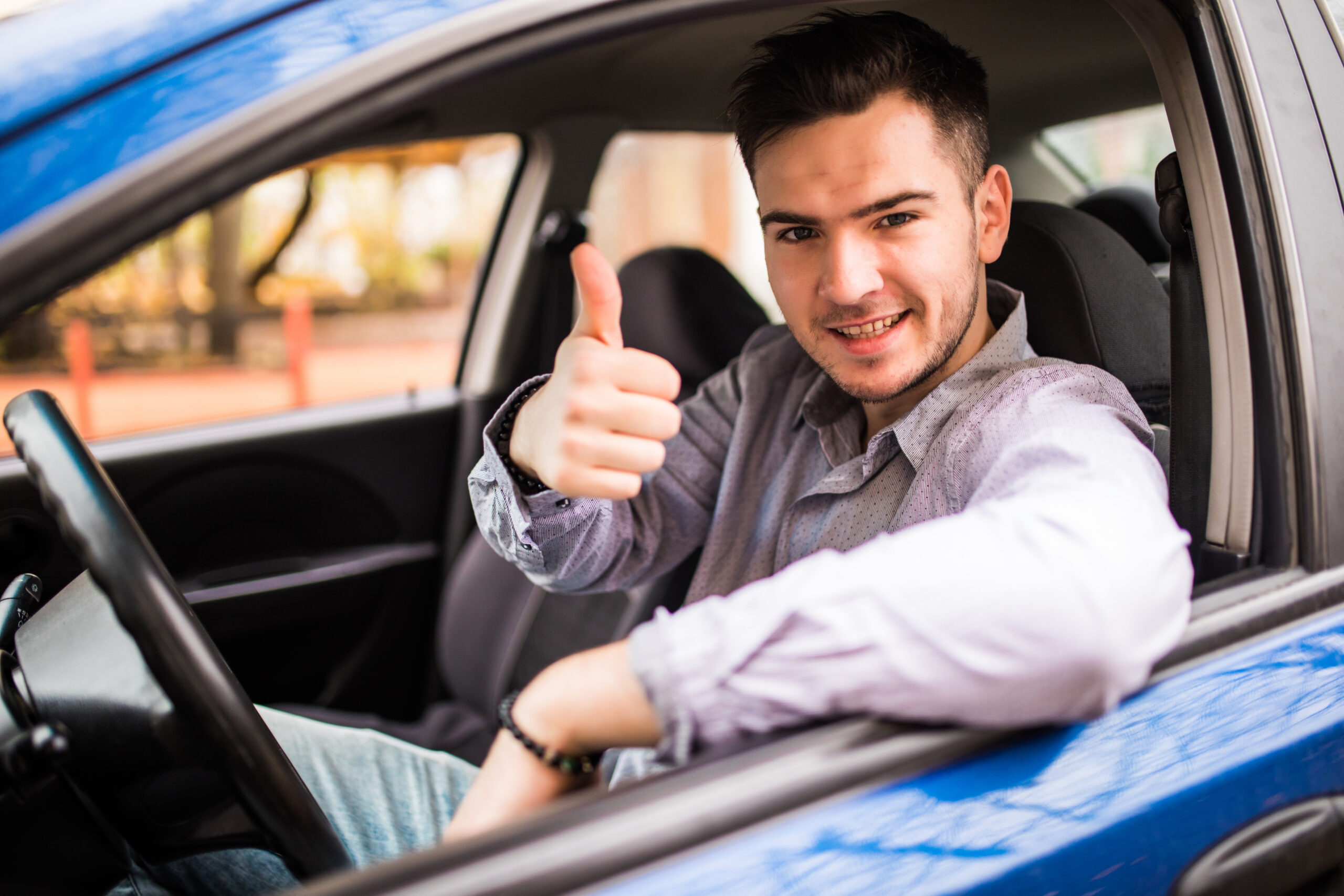 happy smiling man sitting inside car showing thumbs up handsome guy excited about his new vehicle positive face expression scaled